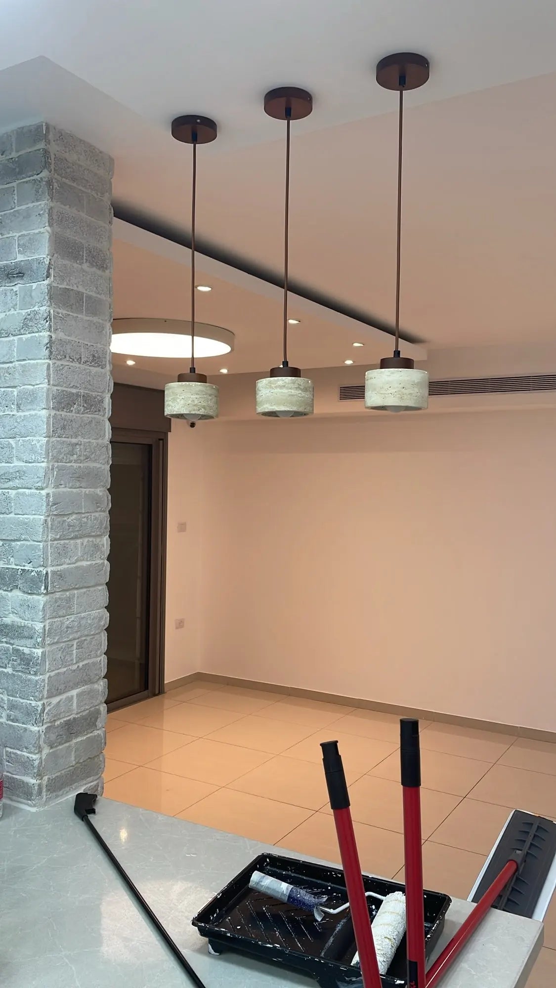 Pair of travertine pendants over a kitchen island