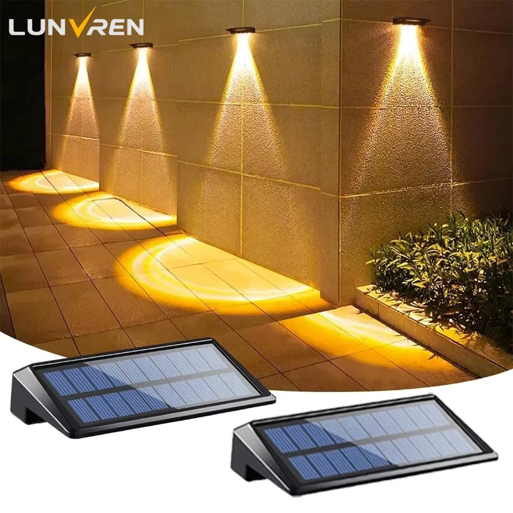 Solar fence lights throwing warm arcs down a garden wall