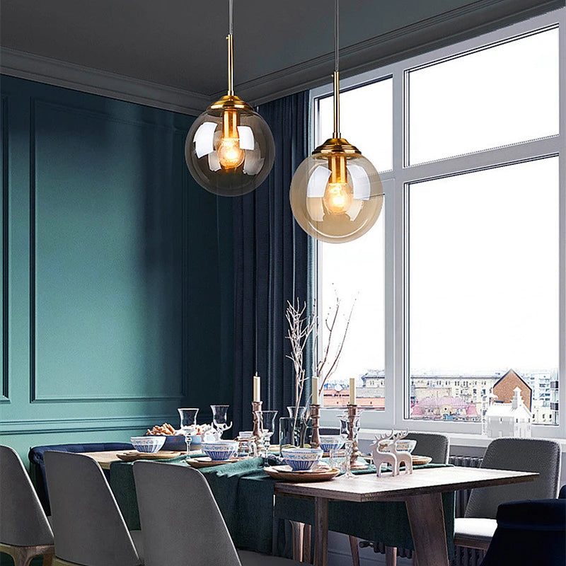 Glass pendants hung in a row over a kitchen island